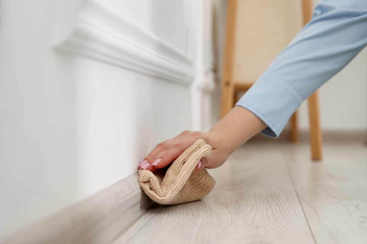 Low dusting baseboard indoors closeup